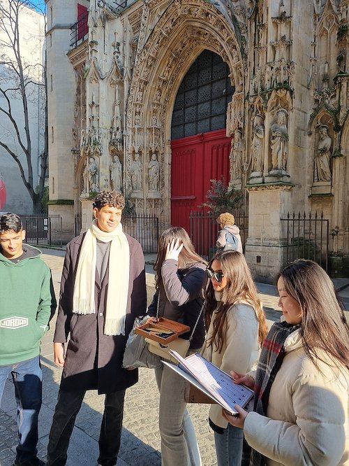 Students with their guide in front of a Gothic church in Paris
